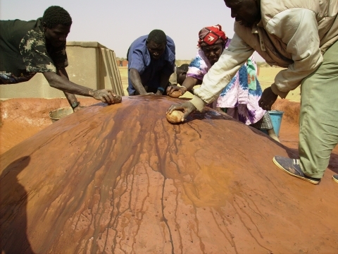 Women teaching Burkinabe masons about traditional renders